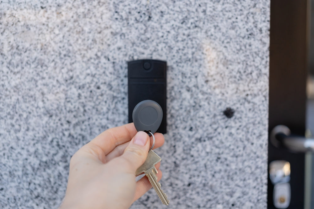 Technician scanning access control fob on modern proximity card reader for upgraded building security