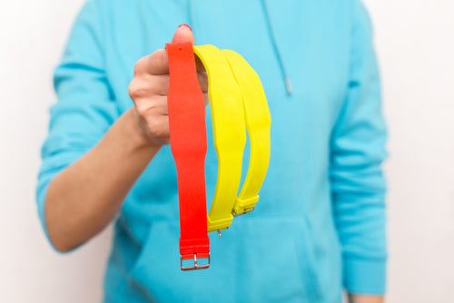 Person holding three RFID access control wristbands in different colors for secure facility access