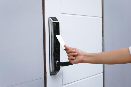 Guest using 13.56 MHz RFID hotel card to unlock NFC-enabled hotel door lock by AuthorizID